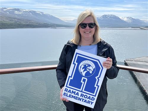 Principal Denny in Iceland holding a Rama sign